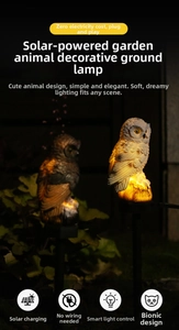 Detail of solar owl garden light with resin owl statue and ground stake at night