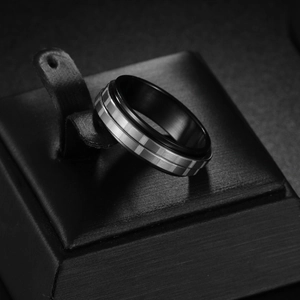 Detail view of a 6mm black rotatable titanium steel ring with silver checkered texture band