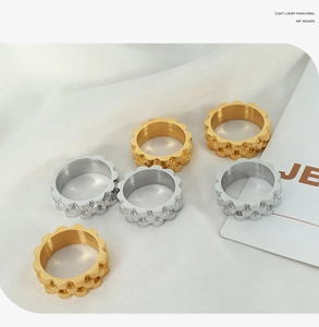 Detail of gold and silver watch-band style rings on a soft white cloth background