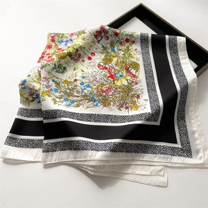 Detailed shot of French floral silk scarf featuring botanical print and black border