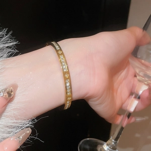 Close-up of sparkling zircon heart bracelet in gold finish worn on a wrist