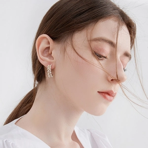 Elegant C-shaped gold hoop earrings with white pearls and sparkling cubic zirconia studs
