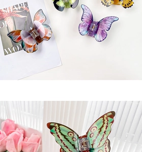 Detailed macro view of colorful resin butterfly hair claws with realistic wing patterns