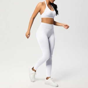 Dettaglio del reggiseno sportivo allacciato al collo bianco e leggings yoga a vita alta