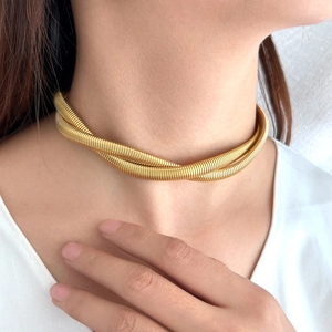 Elegant gold double intertwined snake chain necklace worn by a model in a white V-neck