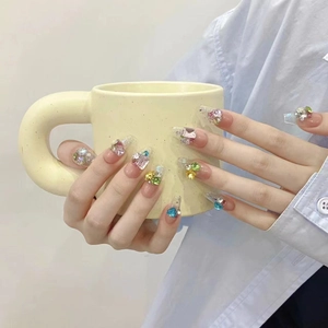 Handmade gradient press-on nails with colorful rhinestones and pearls on a long coffin shape