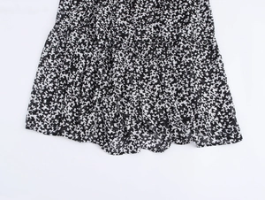 Dettaglio della stampa floreale in bianco e nero sull'orlo della gonna lunga in chiffon