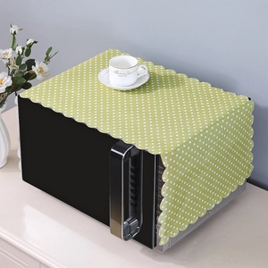 Detailed close-up of grass green polka dot linen microwave cover with scalloped edges