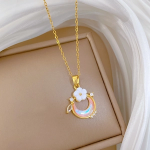 Luxurious gold titanium necklace with white flower and pink opal moon pendant on a soft box