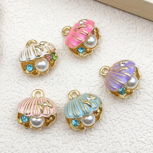 Close-up of five colorful shell pendants with pearls and rhinestones on gold base