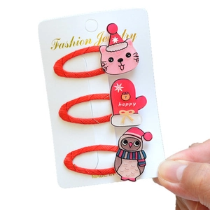Detailed view of red Christmas-themed hair clips with cute resin cat and glove motifs