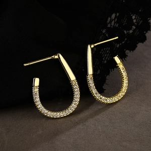 Elegant 18K gold plated C-shaped earrings with pavé zircons on a luxury silk background