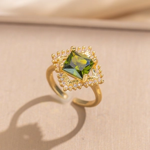 Luxurious gold-plated ring set with green square zircon and sparkling halo accents