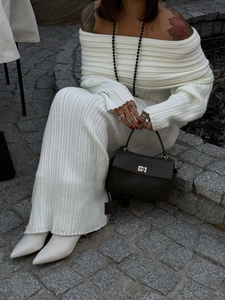 Detailed close-up of white ribbed knit off-shoulder dress with elegant long sleeves