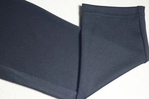 Detail of double-line stitching on the hem of a navy backless sleeveless jumpsuit