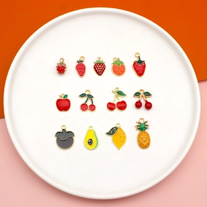 Détail de treize pendentifs en émail fruits comme la fraise pour la création de bijoux DIY