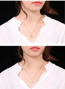 Detail of 18k gold plated necklace with a round purple gemstone pendant worn on neck