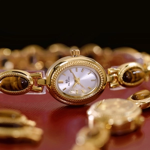 Vintage gold watch with tiger eye stone inlays on a metallic band for elegant women