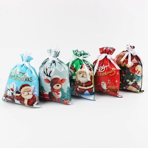 Detail view of five Christmas drawstring gift bags with Santa, reindeer and penguin designs