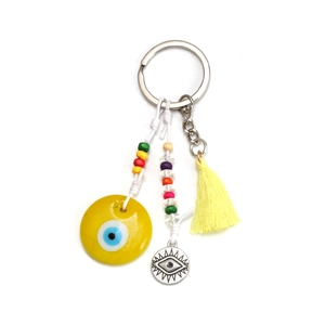 Macro detail of evil eye keychain with yellow tassel and colorful decorative beads