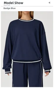 Detail of badge blue sweatshirt with white striped ribbed collar and cuffs