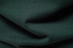 Vue macro du tricot de coton vert foncé montrant la texture fine et la douceur