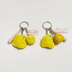 Detail view of mini baseball keychain sets in light and dark yellow with leather gloves