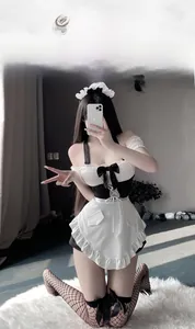 Detail of maid cosplay lingerie set with white lace headband and ruffled black apron dress