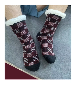 Detailed close-up of red and black plaid knitted floor socks with soft white fleece trim