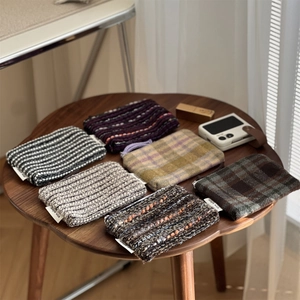 Macro view of vintage striped and plaid mini fabric pouches displayed on a wood table