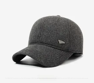 Detail of dark grey winter baseball cap featuring a metal SPORT side emblem and wool texture