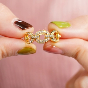 Macro shot of gold-plated chain link ring with shimmering pave-set cubic zirconia crystals