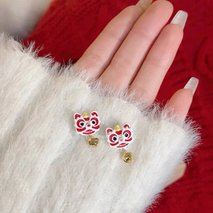 Detailed close-up of festive red and white lion dance earrings with golden bells