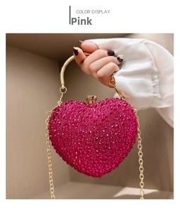 Detail of rose red heart-shaped evening bag with glittering rhinestones and gold handle