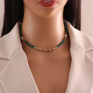 Elegant natural stone and pearl beaded necklace with gold spacers on a model in soft light