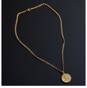 Detail of 18K gold plated Figaro chain featuring a vintage embossed angel coin pendant