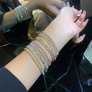 Detail of stacked gold and silver tennis bracelets with glittering crystals on wrist