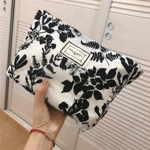Detail of floral bubble cotton pouch featuring 'TIME TO PARTY' label and zipper closure