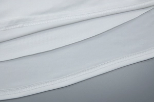 Gros plan sur la texture du tissu blanc et la couture robuste à double aiguille de la robe