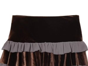 Detail of dark brown velvet mini skirt featuring grey pleated ruffle trim stitching