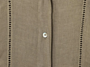 Dettaglio camicia in lino con bottoni di madreperla e ricamo a giorno verticale