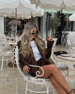 Close-up of leopard print blazer and shorts set worn by model at an outdoor cafe