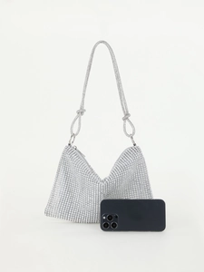 Detailed view of the silver rhinestone evening bag next to a phone for size reference