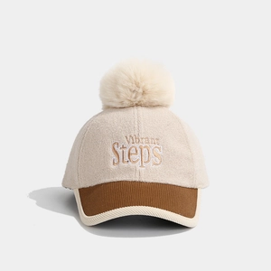Detail of children wool baseball cap with fluffy pompom and Vibrant Steps embroidery