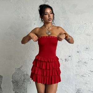 Detailaufnahme der Volants an einem roten trägerlosen Minikleid mit metallischem Blumenschmuck