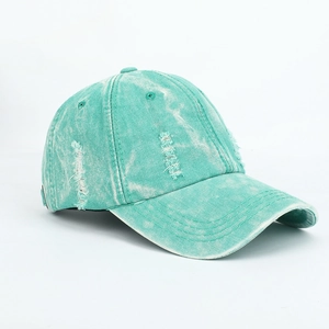 Close-up of mint green washed denim baseball cap with distressed rip details