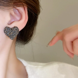 Gros plan d'un clou d'oreille en forme de cœur avec cristaux sombres