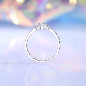 Elegant S925 sterling silver four-prong 4mm moissanite ring with side stones on a bokeh background
