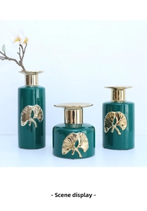 Close-up of emerald green ceramic vases set with golden ginkgo leaf relief patterns
