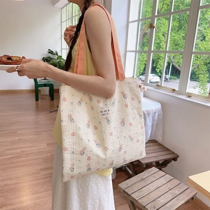 Detail of embossed rabbit canvas tote bag featuring pink straps and sozakka beauté label
